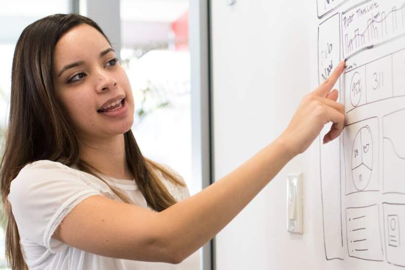 A woman pointing to a work plan.